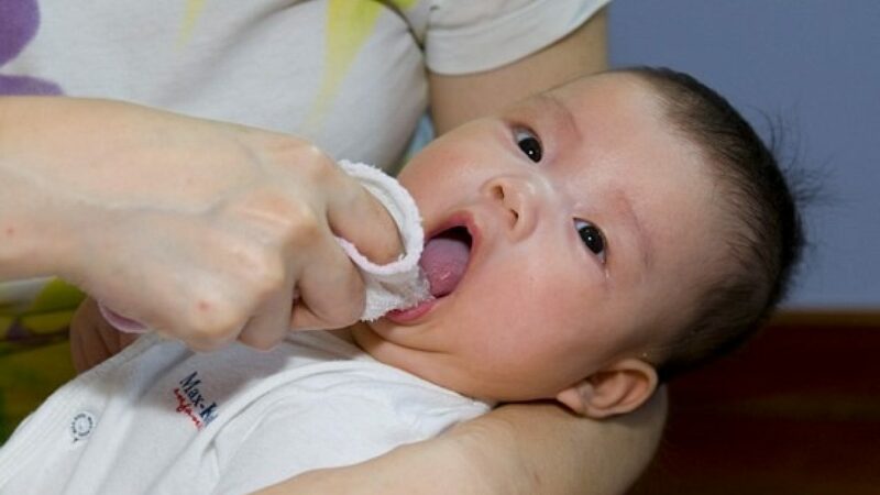 Cha mẹ nên bắt đầu từ việc rơ lưỡi để tạo thói quen chăm sóc răng miệng cho bé